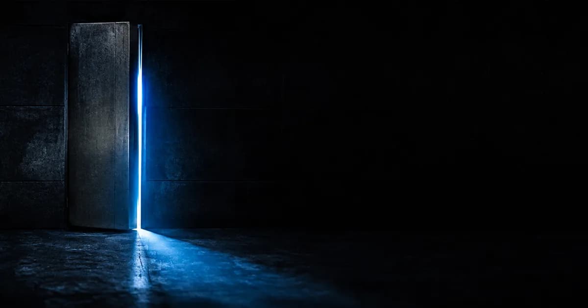 Porte blindée entrouverte laissant passer une lumière bleue dans une pièce sombre